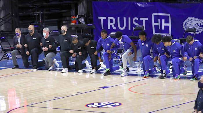 Kentucky Wildcats coaches and players kneel during the national anthem prior to a game against the Florida Gators on Jan. 9, 2021.